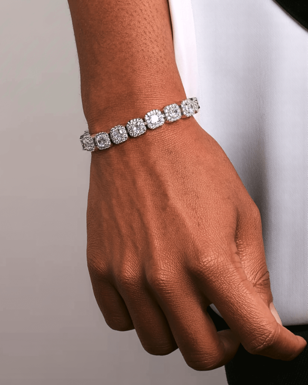 Clustered silver tennis bracelets 10MM and 12MM on a hand, with sleek silver stones