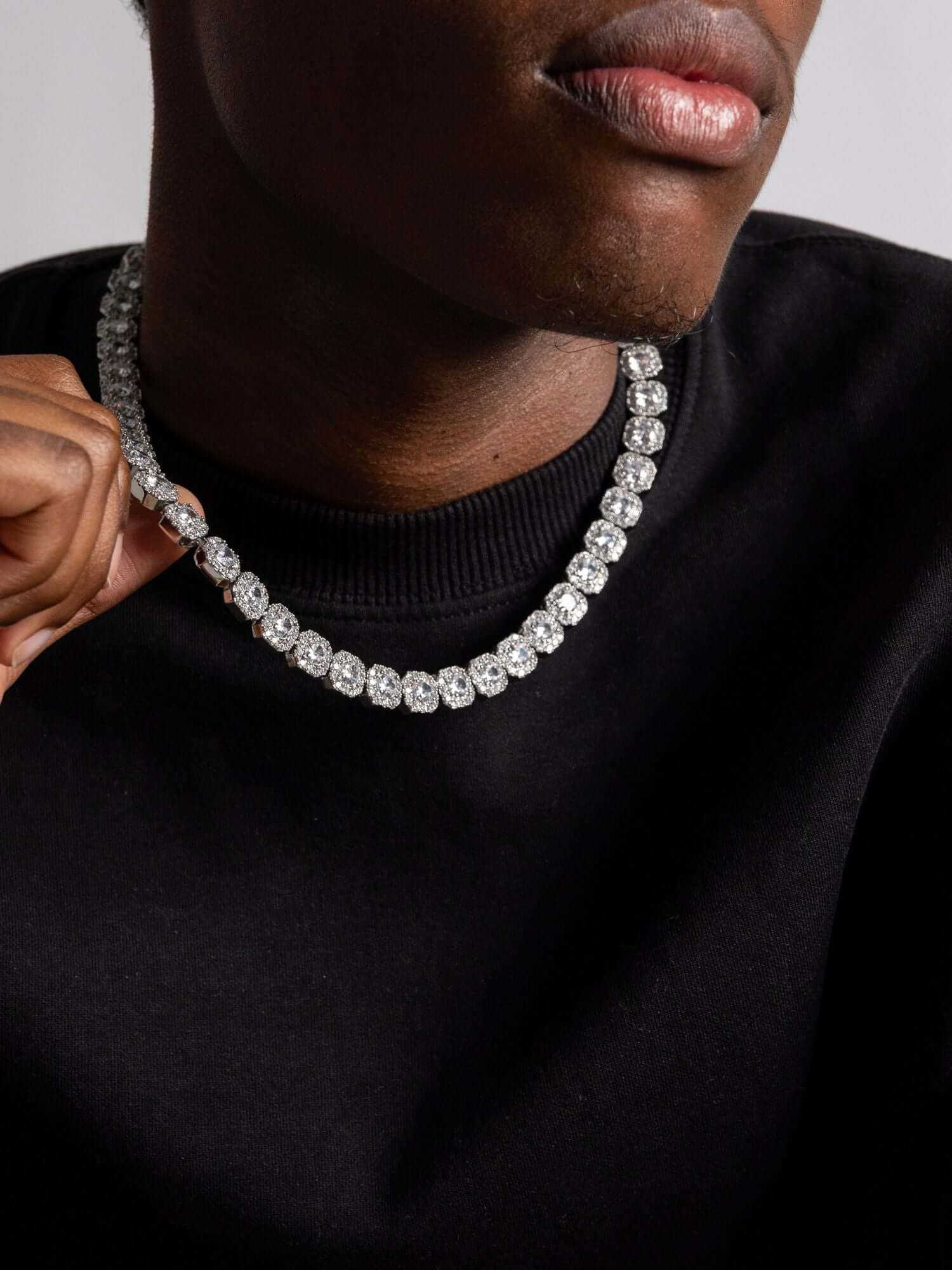 Clustered zilveren tennis ketting 10MM-12MM op een man in een zwart T-shirt, benadrukt de unieke textuur.