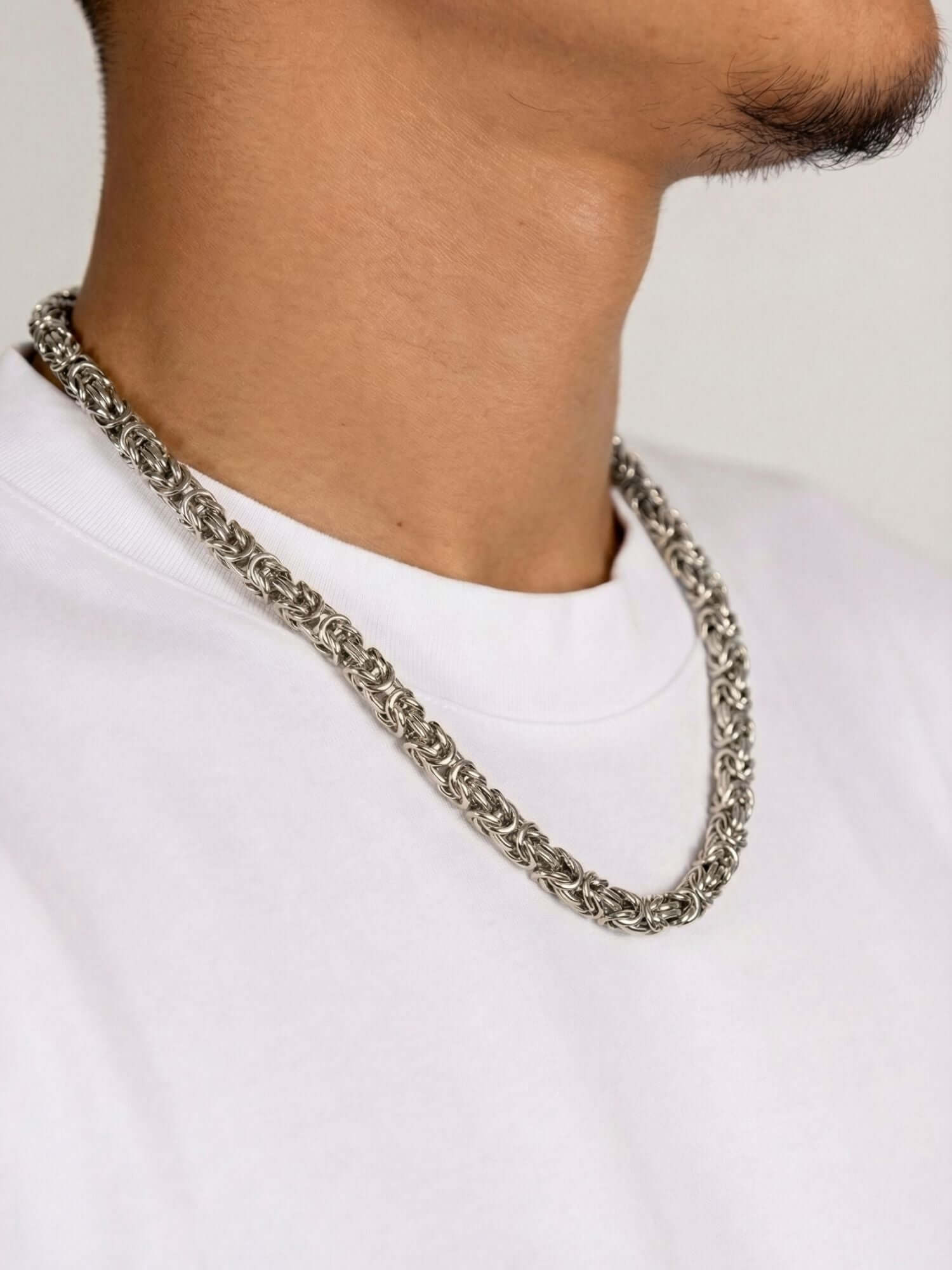 Zilveren Byzantijnse Konings Ketting 6MM gedragen door een man op een witte shirt.