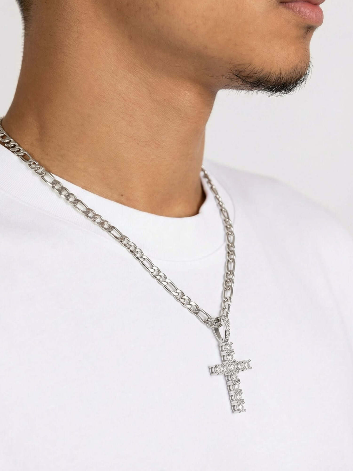 Ciondolo Zilveren Kruis ICED OUT indossato da un modello con collana d’argento e maglietta bianca.