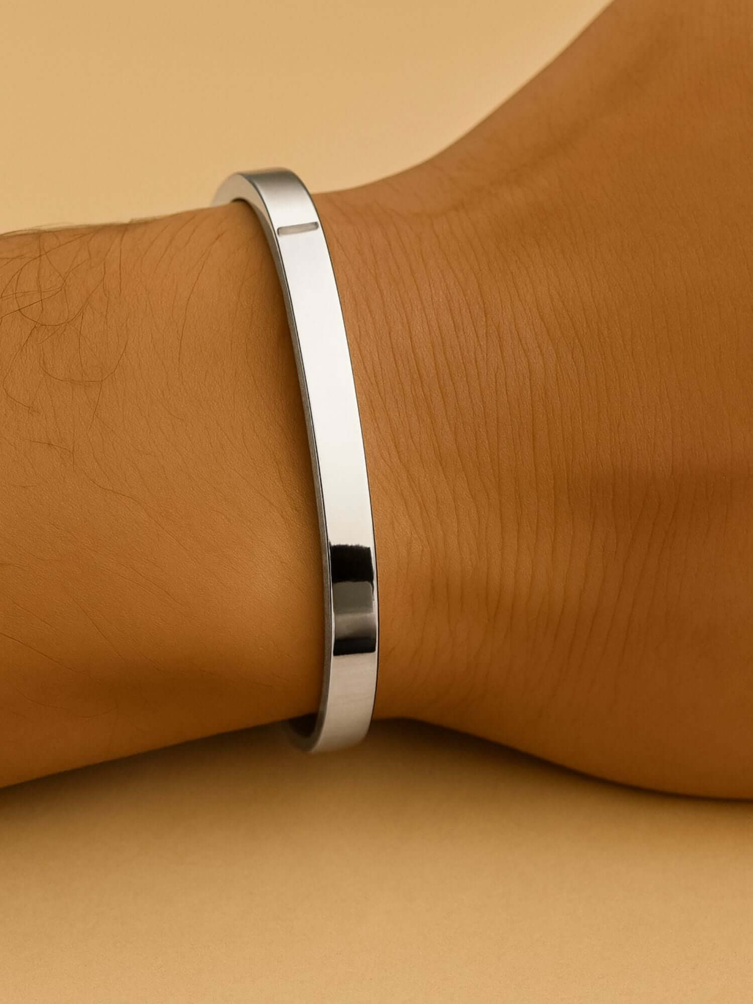 Zilveren cuff armband 3MM en 5MM elegant op een pols, met een minimalistisch design en moderne luxe.